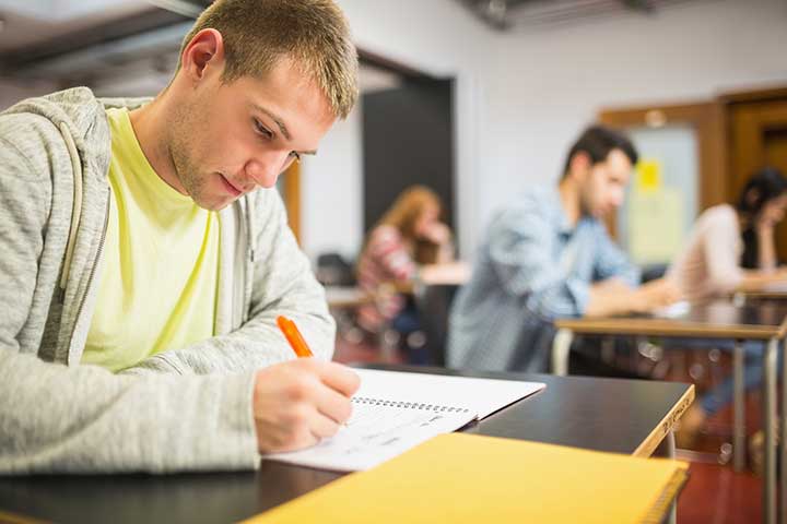 man sitter i provsal och skriver högskoleprovet
